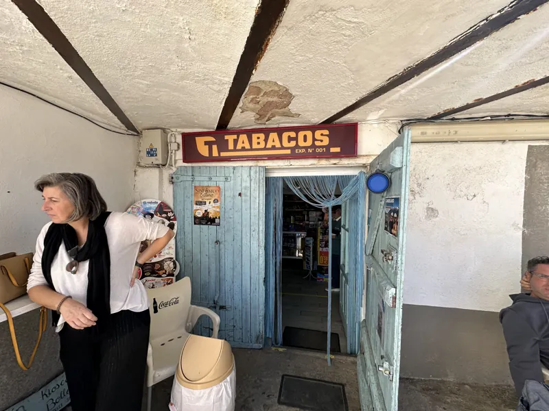 Front of El Rincón de La Corita with its blue door and tobacco sign